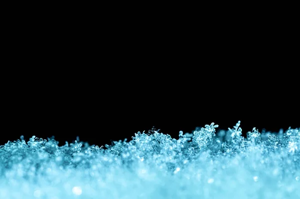 窓の柔らかい青の色調で雪のフレークが閉じられた自然な雪のテクスチャは テキストのためのスペースと黒の背景に隔離されています 休日のギフトカードのためのブランク 雪のマクロな質感 — ストック写真