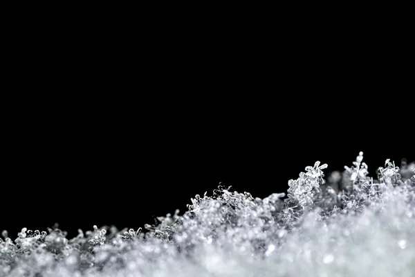 黒い背景に隔離された窓の上に雪のフレークを閉じ込めた自然な雪のテクスチャ 休日のギフトカードのためのブランク 雪のマクロな質感 — ストック写真