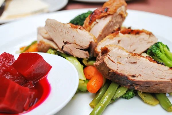 Trozos de carne en un plato blanco con remolacha —  Fotos de Stock