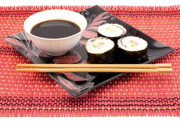 用筷子红垫子上黑色印版上的寿司 — 图库照片