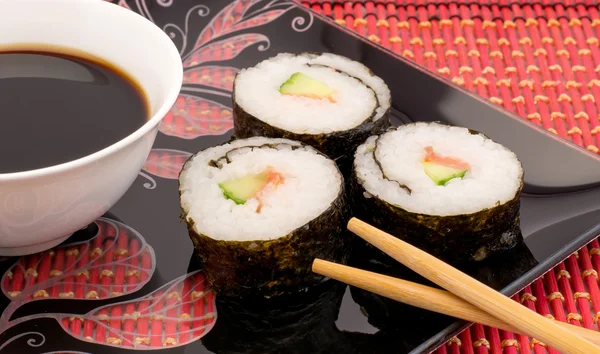 寿司用筷子红垫子上的黑色板上关闭 — 图库照片