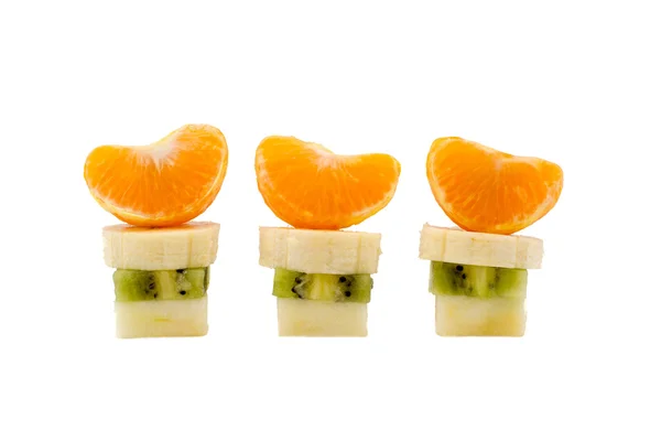 Tres columnas de corte de plátano kiwi manzana y mandarina sobre un fondo blanco — Foto de Stock