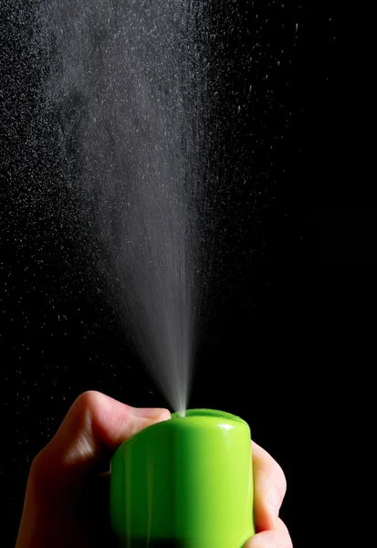 Hand presses the air freshener on a black background — Stock Photo, Image