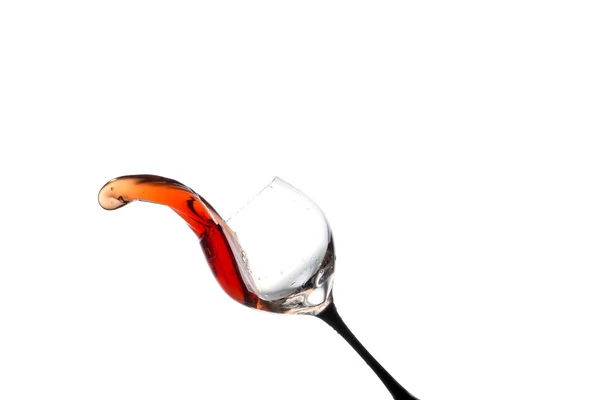 Stream of wine being poured out off a glass isolated on a white background — 图库照片