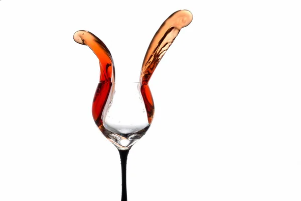 Stream of wine being poured out off a glass isolated on a white background — Φωτογραφία Αρχείου