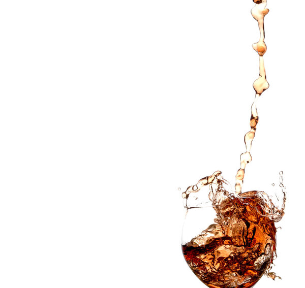 stream of wine being poured into a glass isolated on a white background