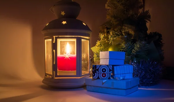 Lanterna com vela acesa e árvore de Natal com caixas de presente com belas sombras e com um brilho bonito como uma estrela — Fotografia de Stock