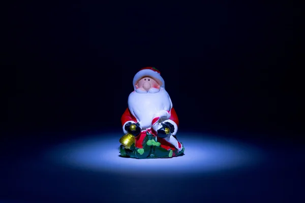 Papai Noel em cima da lanterna acesa com um brilho bonito como uma estrela em um conto de fadas em um fundo preto — Fotografia de Stock