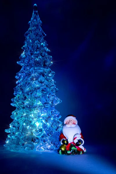 Juguete de árbol de Navidad que brilla con una hermosa sombra Fondo Northern Lights y destaca en forma de estrellas con un juguete Santa Claus —  Fotos de Stock
