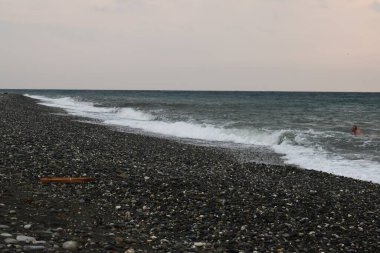 Deniz kıyısı geçmişi. Siyah kum, taşlar ve deniz dalgaları