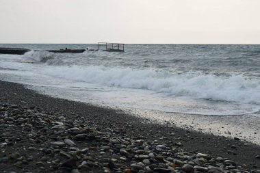 Deniz kıyısı geçmişi. Siyah kum, taşlar ve deniz dalgaları