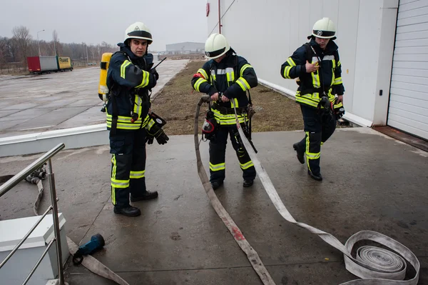 Brandmän släcka en villkorlig brand — Stockfoto