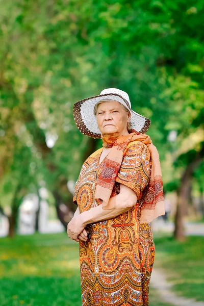The elderly woman walks on park — Stock Photo, Image