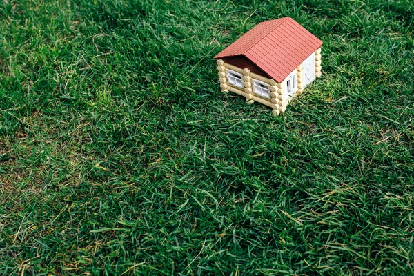 Деревянный дом из бревна против травы — стоковое фото