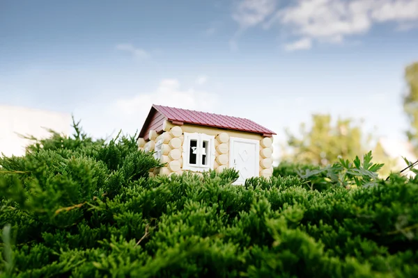 A casa de madeira de um log contra uma grama — Fotografia de Stock