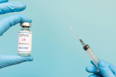 Doktor bir aşı kaydı tutuyor ve Corona virüsü aşı tüpleri. Koronavirüse karşı dokunulmazlık pasaportu bir erkek doktorun elinde. COVID-19 tedavisinin kanıtı olarak sağlık pasaportu.