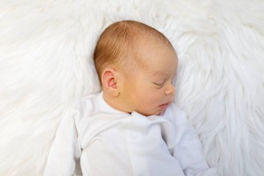 Beyaz yatak odasında bir haftalık sevimli bir bebek. Yeni doğmuş çocuk yatakta dinleniyor. Küçük çocuklar için çocuk odası. Çocuklar için tekstil ve yatak. Aile sabahı evde. Yaşam tarzı konsepti, gerçek hayat..