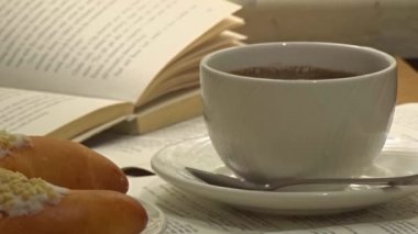 Beyaz fincan gerçekten sıcak sigara kahve kitap kağıtları ile tatlı yaprak üzerinde ve arka plan üzerine açık kitap