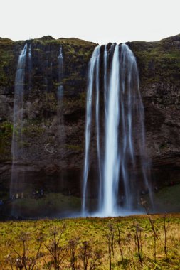 Çimen gökkuşaklı şelaleli vadi