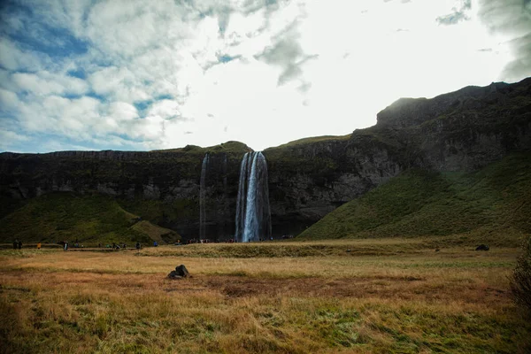 Çimen gökkuşaklı şelaleli vadi