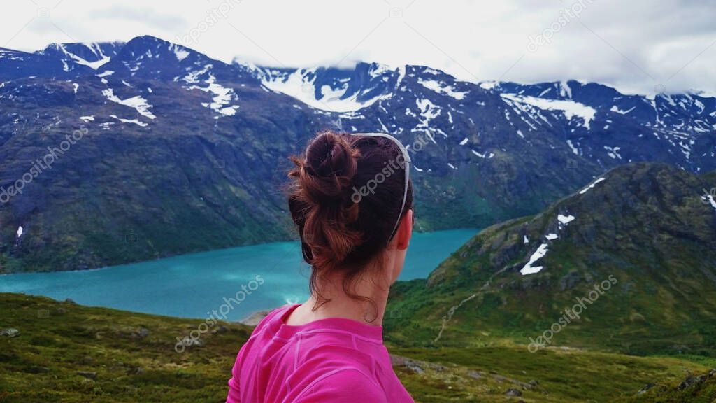Female hiker looking over a spectacular view over a Norwegian fjord on a summers hike.