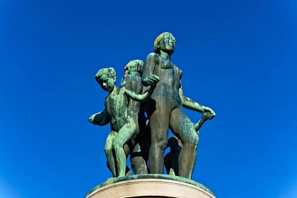 Bronze statue with green patina, resemblance of women and children dancing naked.