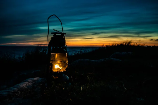 夕暮れ時には海のオレンジ色の炎で燃える古い古典的なオイルランタン そうだ 高品質の写真 — ストック写真