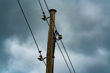 Porselen tutacaklarda elektrik ve telefon hatları olan eski ahşap bir direk. - Evet. Yüksek kalite fotoğraf