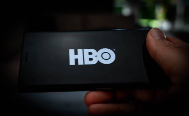 Ekranda HBO logosu olan bir cep telefonunu tutarak yayın hizmetlerini resmedeceğiz. Yüksek kalite fotoğraf