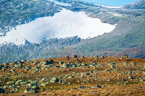 高山高原上散布着上个冰河时期的大石头 橙色和黄色的秋色和白色的山峰背景 是的高质量的照片 — 图库照片