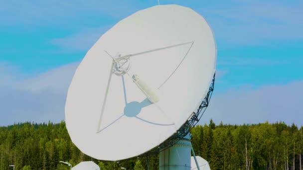 Большой белый радиолокационный диск с голубым небом и деревьями на заднем плане. — стоковое видео