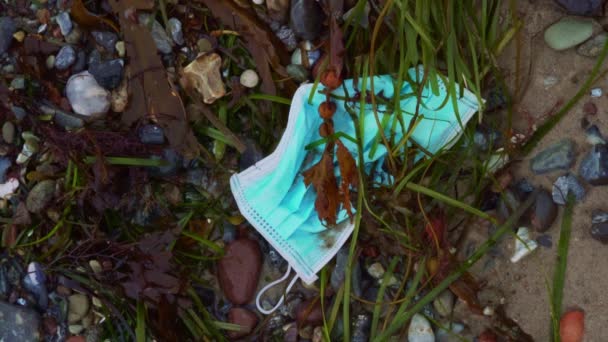 Gebrauchte Gesichtsmaske Aus Der Coronavirus Pandemie Als Müll Strand Angeschwemmt — Stockvideo