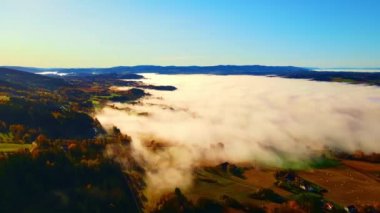 Gün doğumunda kırsal bir vadide yoğun bir sabah sisi. 4K hava görüntüsü.