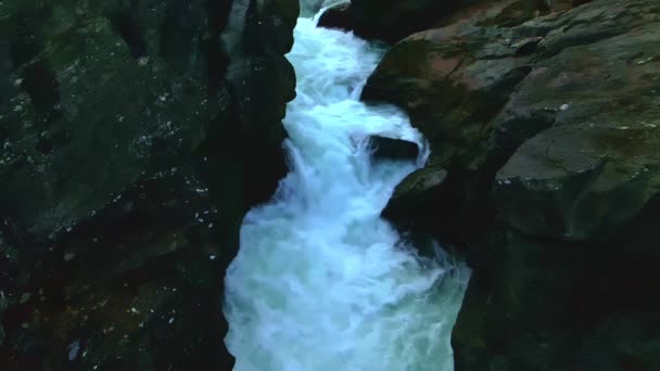 暗い岩の中を流れる川の速い滝のスローモーションビデオ — ストック動画