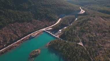 Mavi su deposu olan bir dağ vadisinde hidroelektrik barajı. 4K hava görüntüsü.