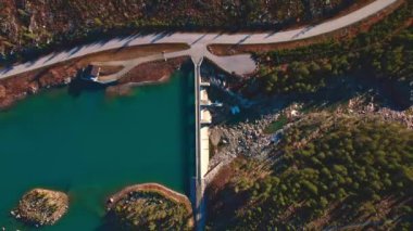 Su deposu ve nehri yukarıdan görülen hidroelektrik barajı. 4K hava görüntüsü yükseliyor.