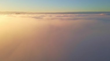 Bulutların üzerinde uçarak altın bir günbatımına doğru.