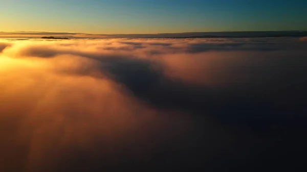 Flyg över molnen till en gyllene solnedgång. — Stockfoto