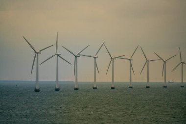Okyanus rüzgarlarından temiz yeşil enerji üreten devasa açık deniz rüzgar türbinleri. Yüksek kalite fotoğraf
