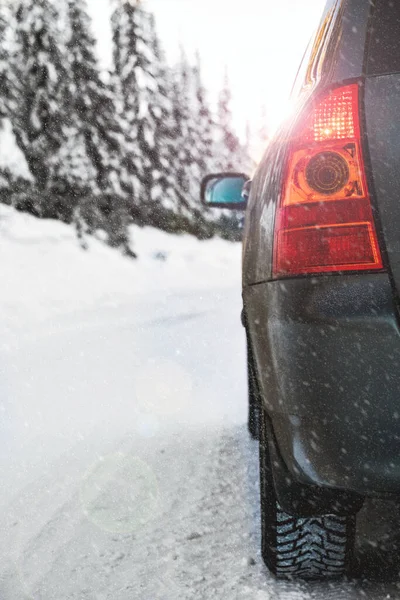 Car driving on a winter road in the snow. Close up, shallow depth of field. High quality photo