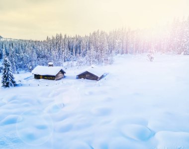 Vahşi doğada kış günbatımında derin karlarla kaplı Idyllic dağ kulübesi. Yüksek kalite fotoğraf