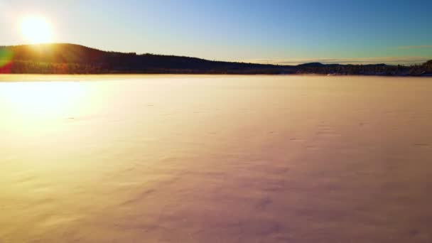 夕阳西下 飞越冰封的湖面上闪烁着白雪的北极荒野 — 图库视频影像