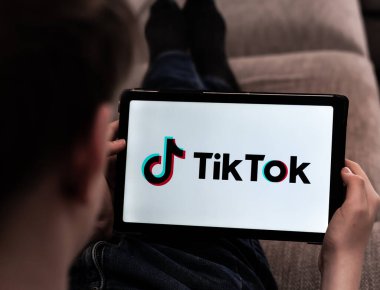 Çocuk, TikTok videolarını bir tablette tarıyor. Yüzeyin derinliği. Yüksek kalite fotoğraf