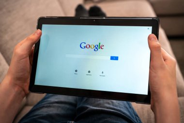 İnternette arama yapmak için Google arama uygulamasını kullanan tabletli bir kişi. Yüzeyin derinliği. Yüksek kalite fotoğraf
