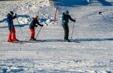 Aile dağlık bir kayak merkezinde kayak yapıyor..