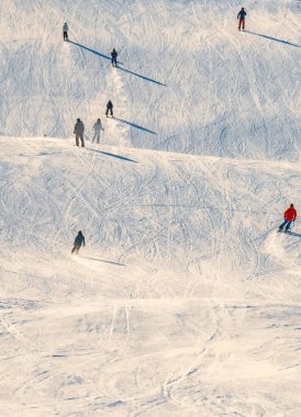 Güneşli bir günde kayak merkezinde yamaçtan aşağı kayan kayakçılar. Yüksek kalite fotoğraf