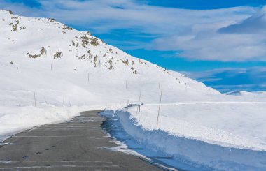 Kışın ortasında karla kaplı bir dağ geçidinde dar bir yol. Yüksek kalite fotoğraf