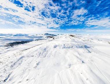 Açık bir soğuk kış gününde, kar kaplı kutup dağları ve ıssız arazi üzerindeki çarpıcı panoramik manzara. Yüksek kalite fotoğraf