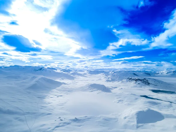 Spectacular panoramic view over snowcapped mountain peaks, ridges and frozen highland tundra in Jotunheimen, Norway. High quality photo