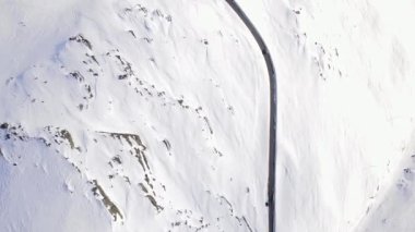 Dar bir yolda trafik vardı. Çarpıcı bir karın içinden geçiyordu. Dağ yabanı kaplıydı..